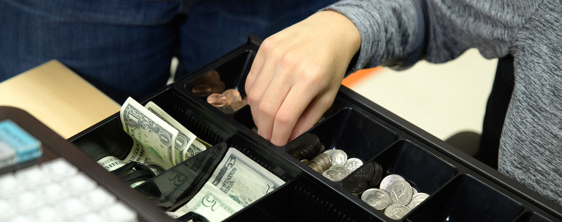 Close up of student getting change in cash register