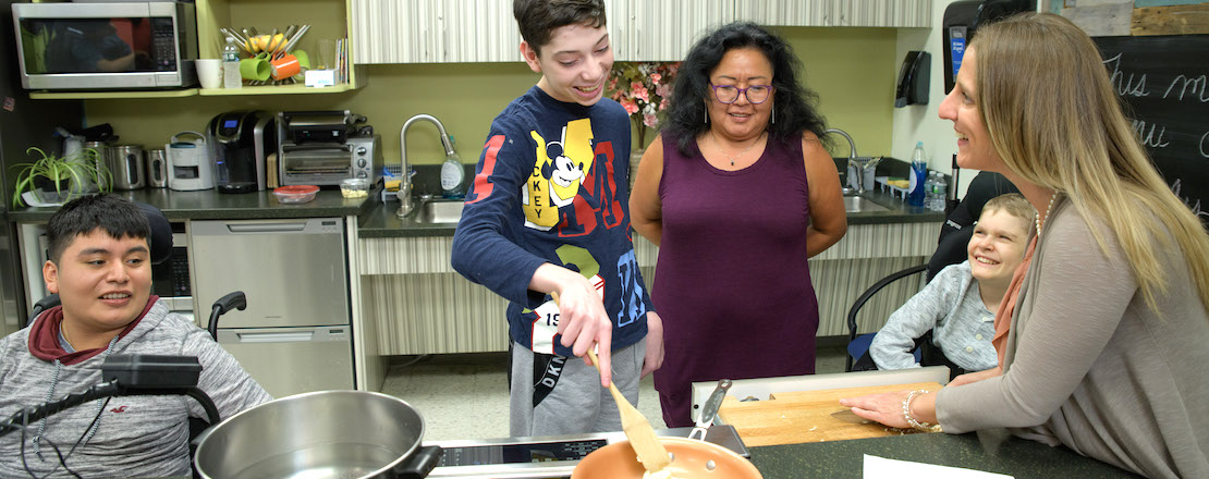 Students and teachers cooking in kitchen