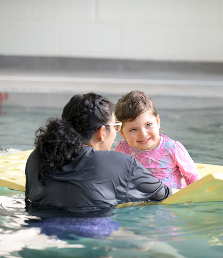 Young girl and therapist in pool