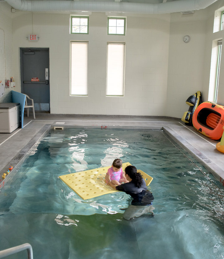 Student and therapist in pool