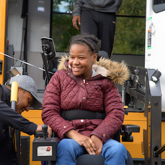 Girl in wheelchair coming off school bus