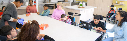 Teachers and student sitting around kitchen table